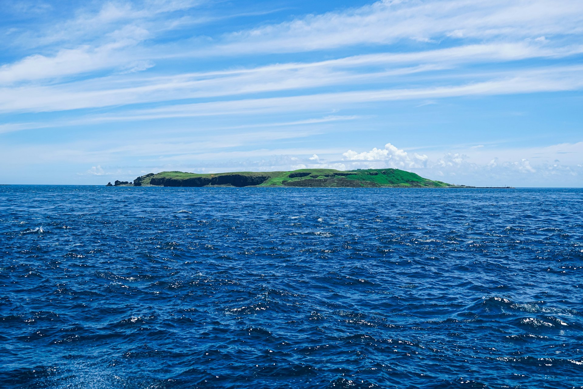 green and brown island under blue sky during daytime